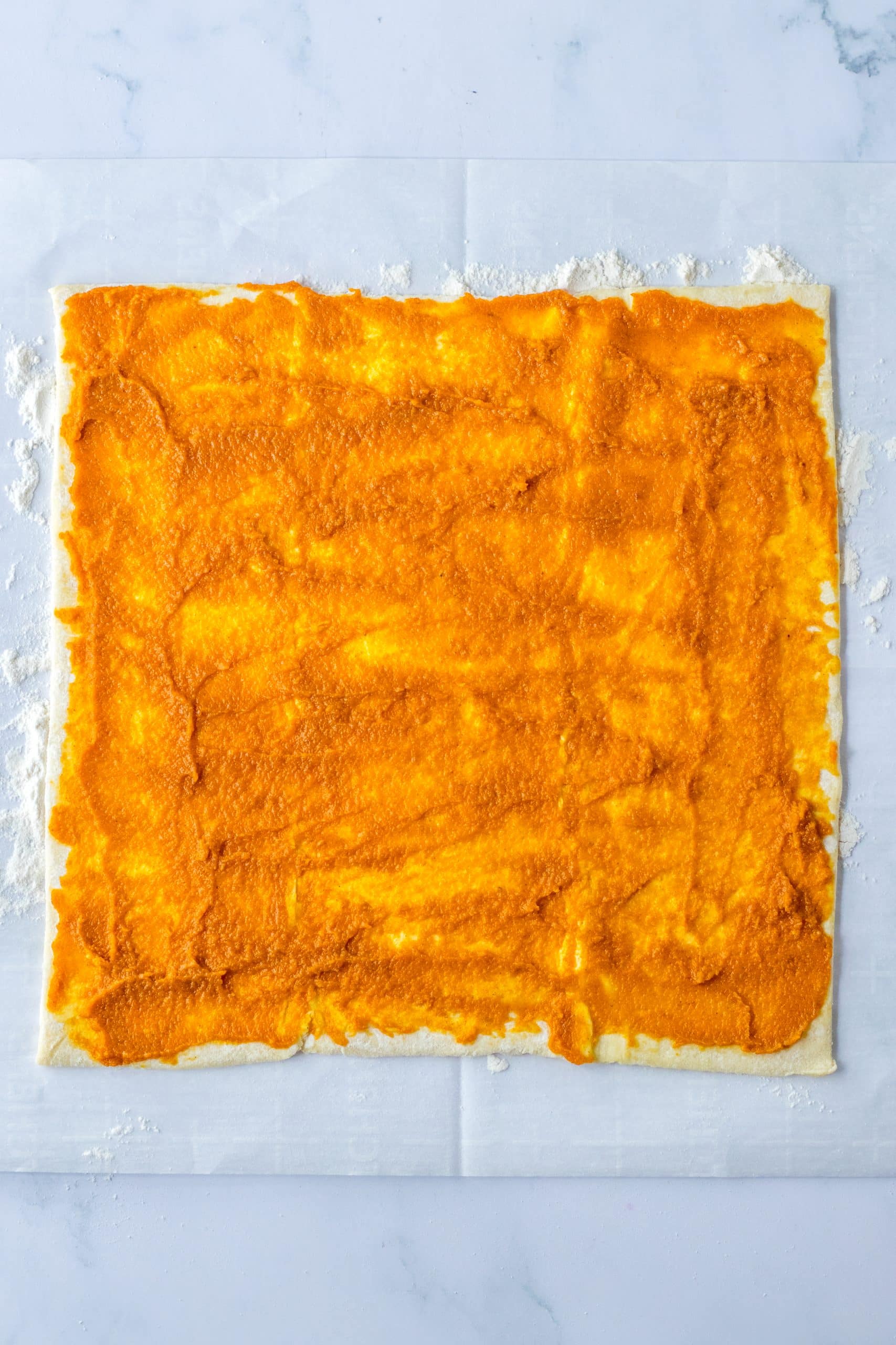 a sheet of flattened puff pastry spread with pumpkin pie filling