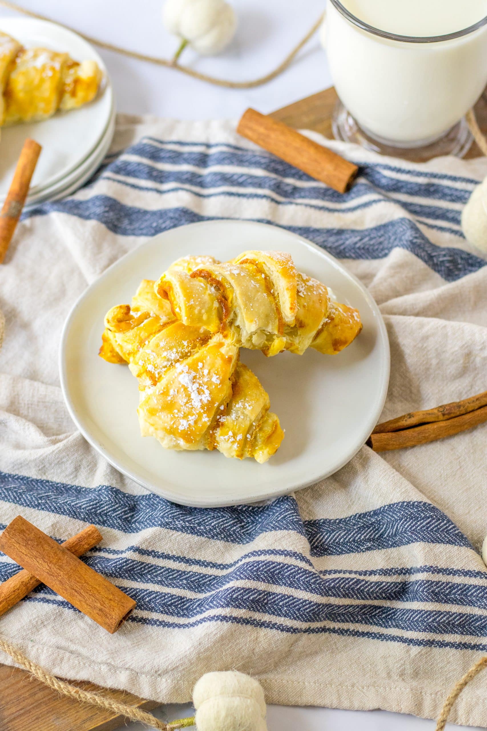 two pumpkin pie crescent rolls on a small white plate