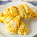 two pumpkin pie crescent rolls on a small white plate