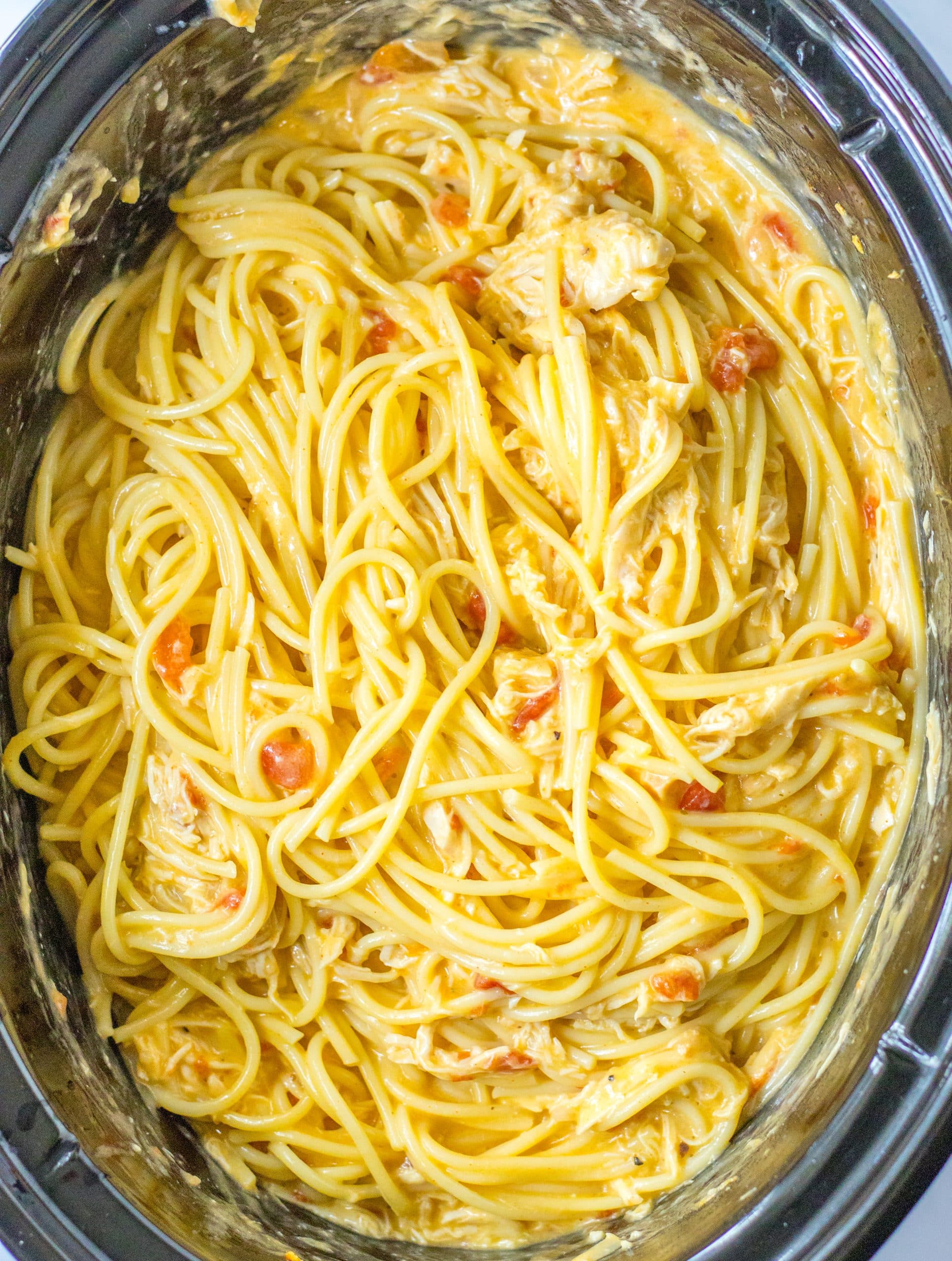 slow cooker chicken spaghetti in the black bowl of a crockpot