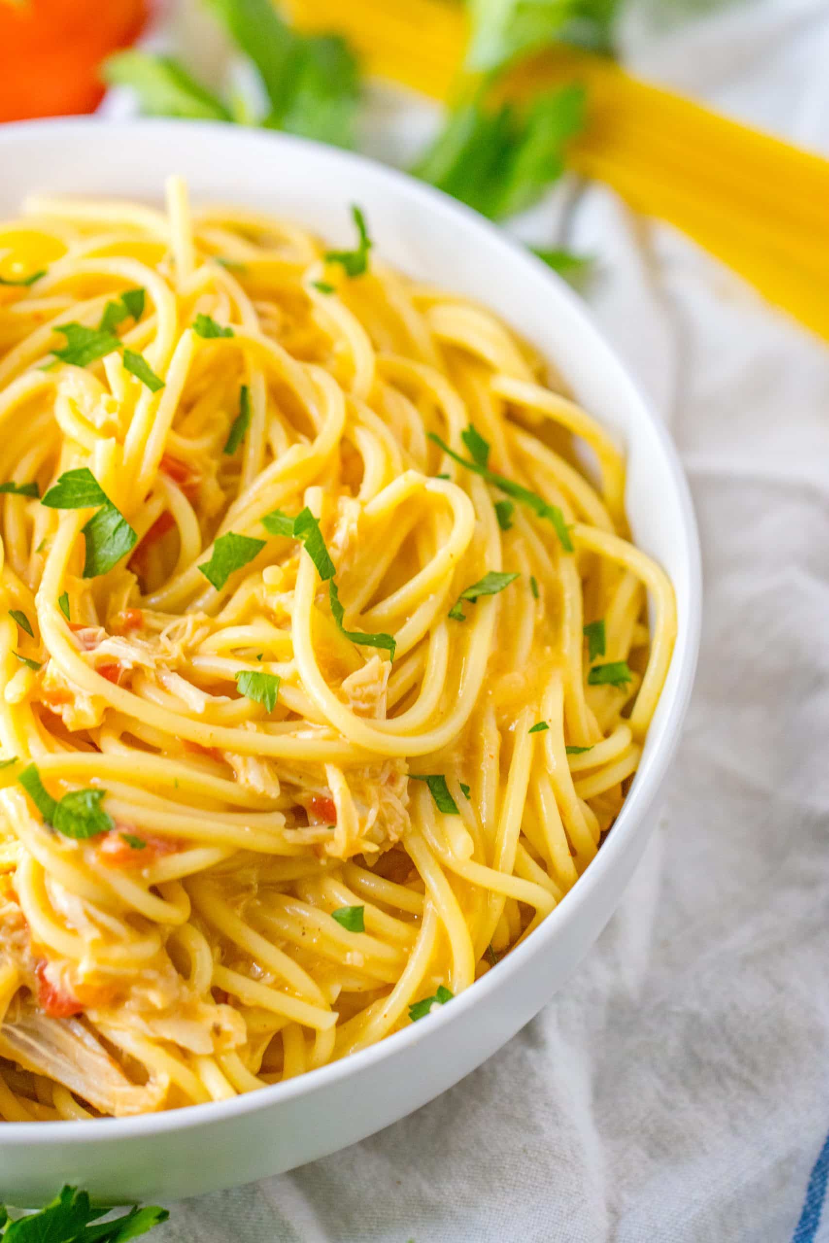slow cooker chicken spaghetti in a white serving bowl