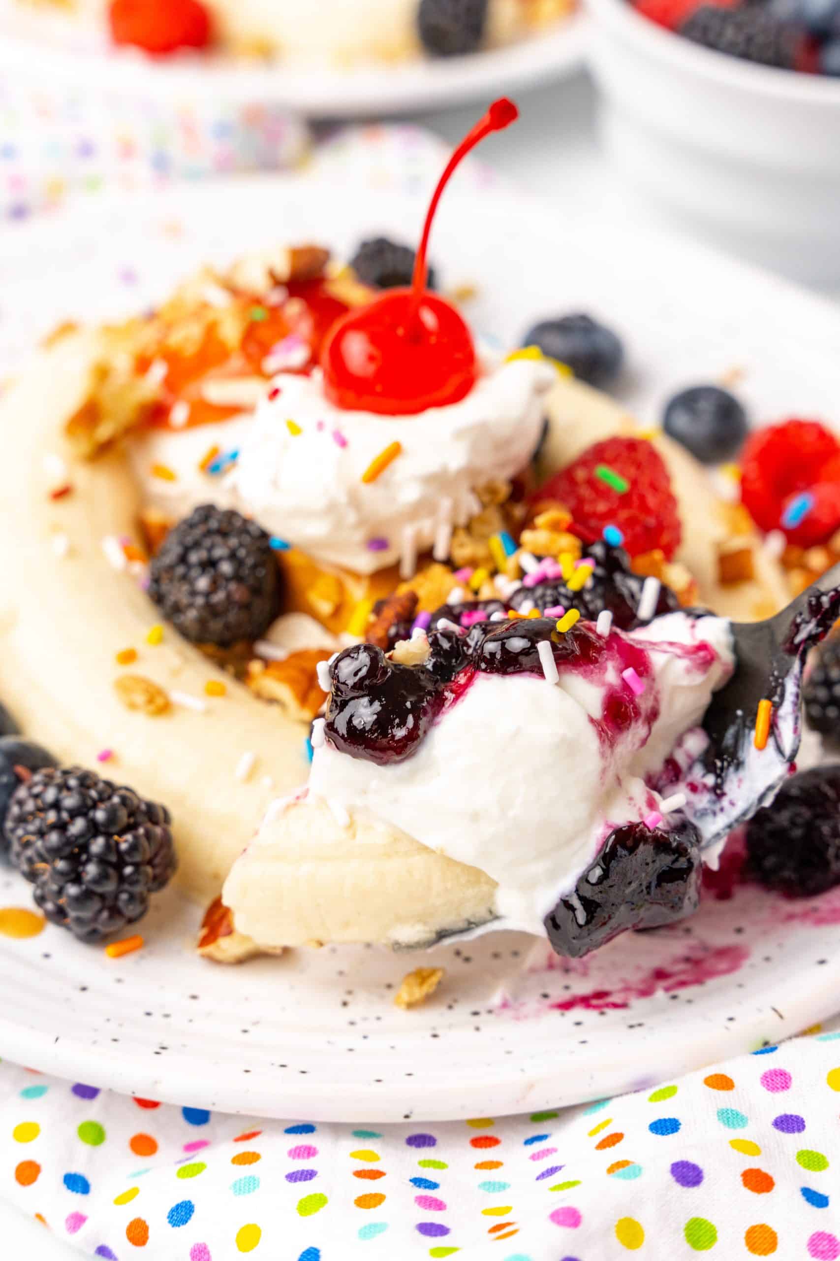 a black fork holding up a scoop of a breakfast banana split
