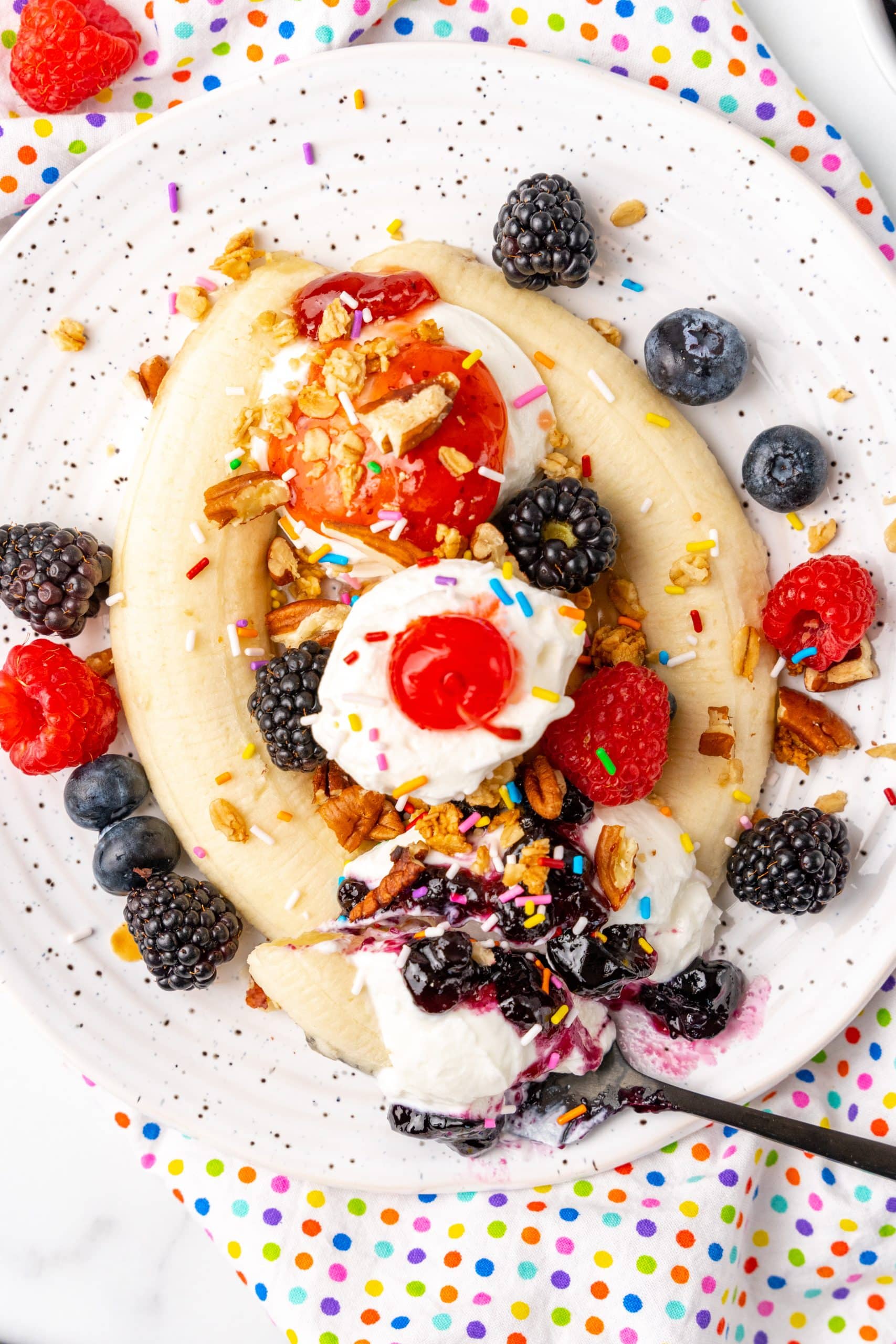 breakfast banana splits on white plates with fresh berries