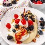breakfast banana splits on white plates with fresh berries