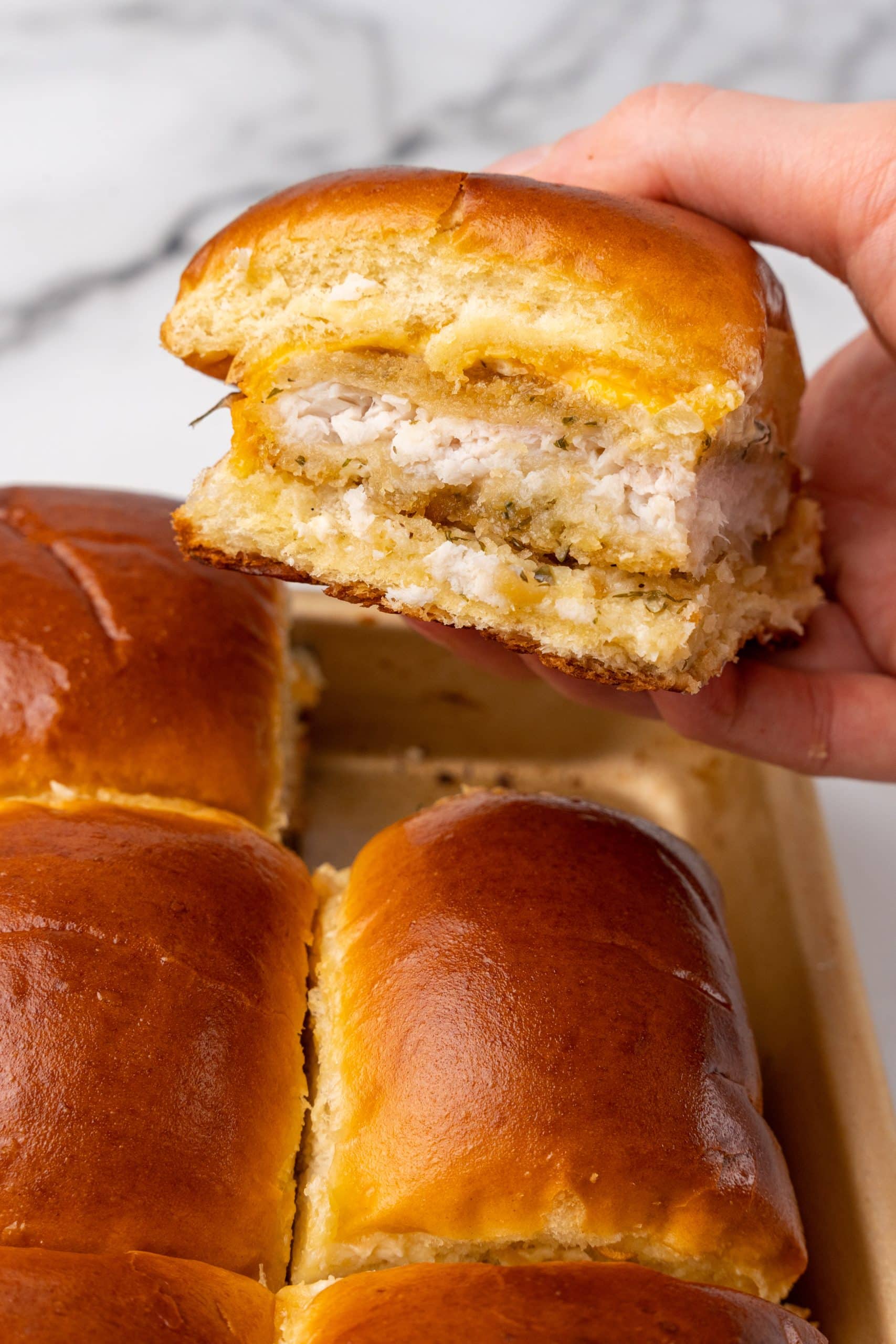 a hand holding up a single filet-o-fish sliders