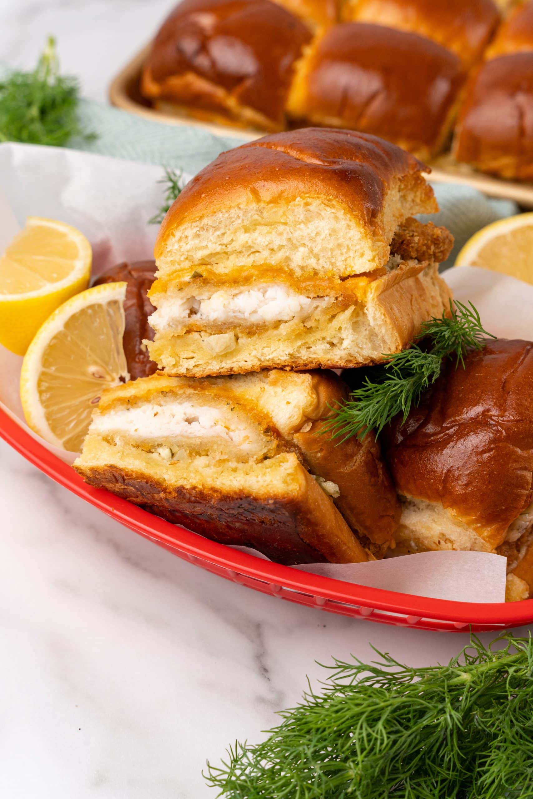 filet-o-fish sliders in a red food basket with lemon wedges on the side