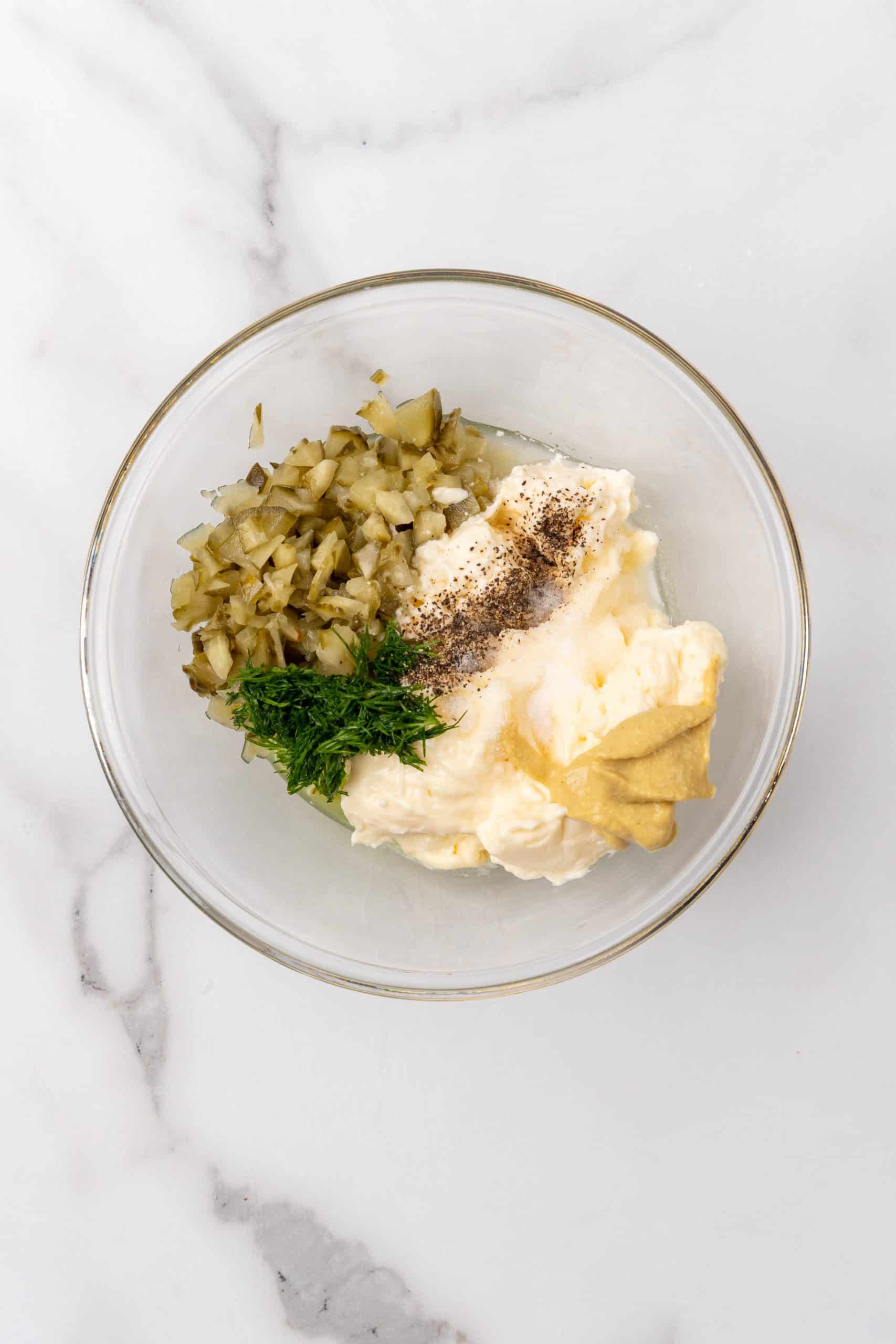 homemade tartar sauce ingredients in a glass mixing bowl