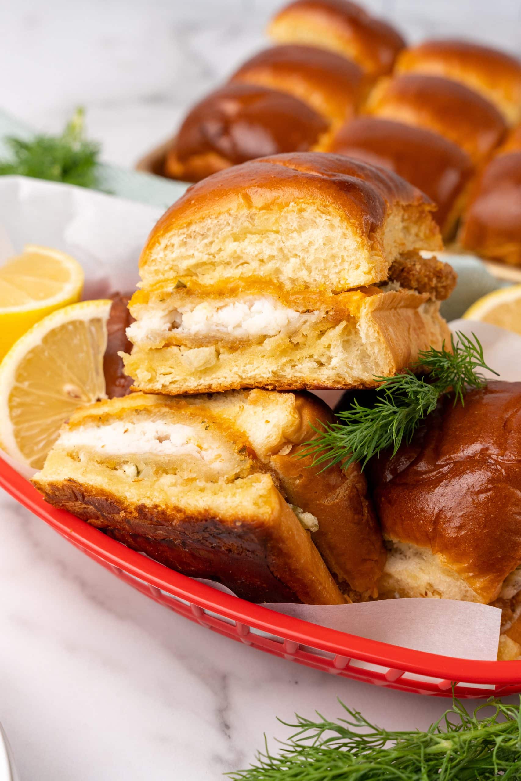 filet-o-fish sliders in a red food basket with lemon wedges on the side