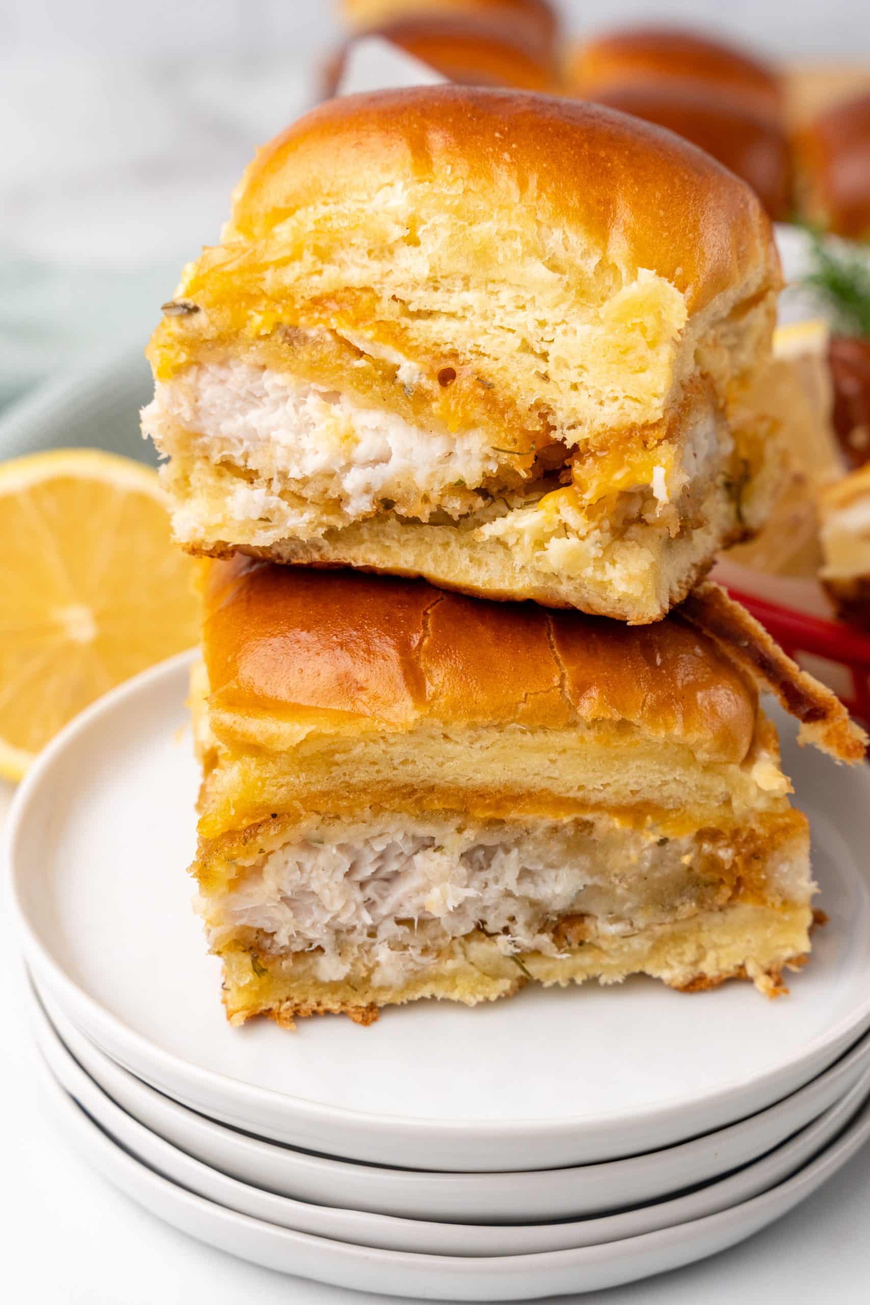 two fish fillet sliders stacked on a small white plate