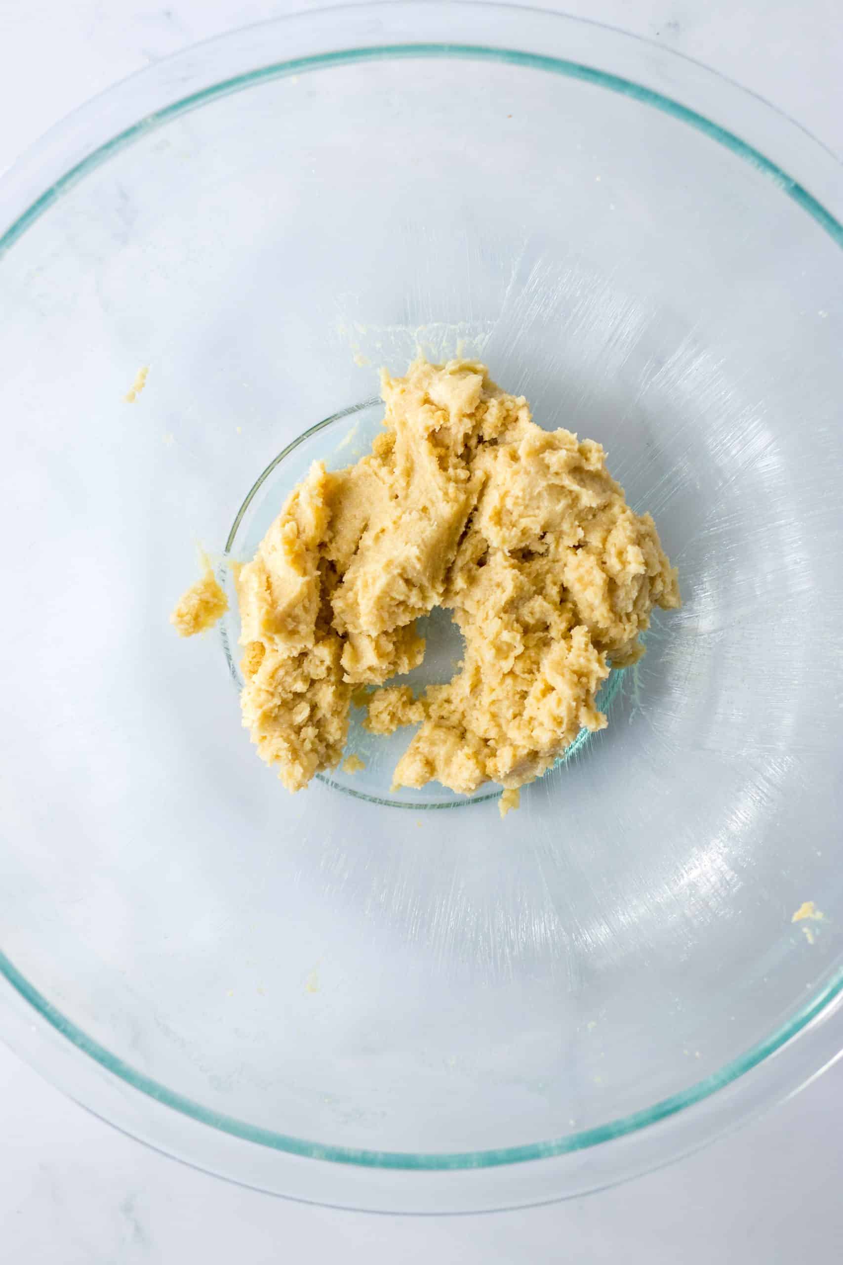 butter and sugars creamed together in a glass mixing bowl