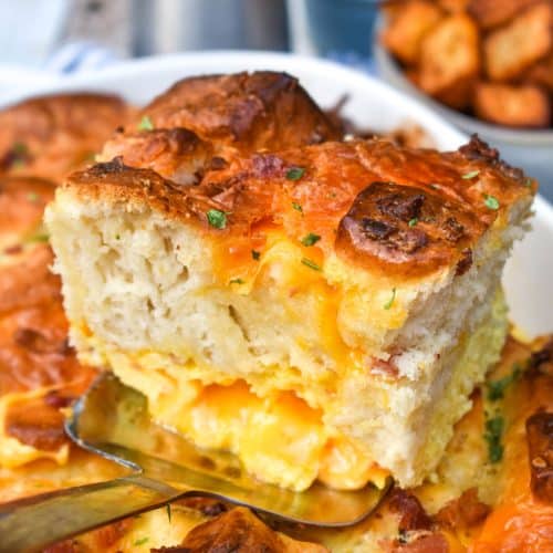 a slice of cheesy breakfast biscuit bake resting on a silver spatula