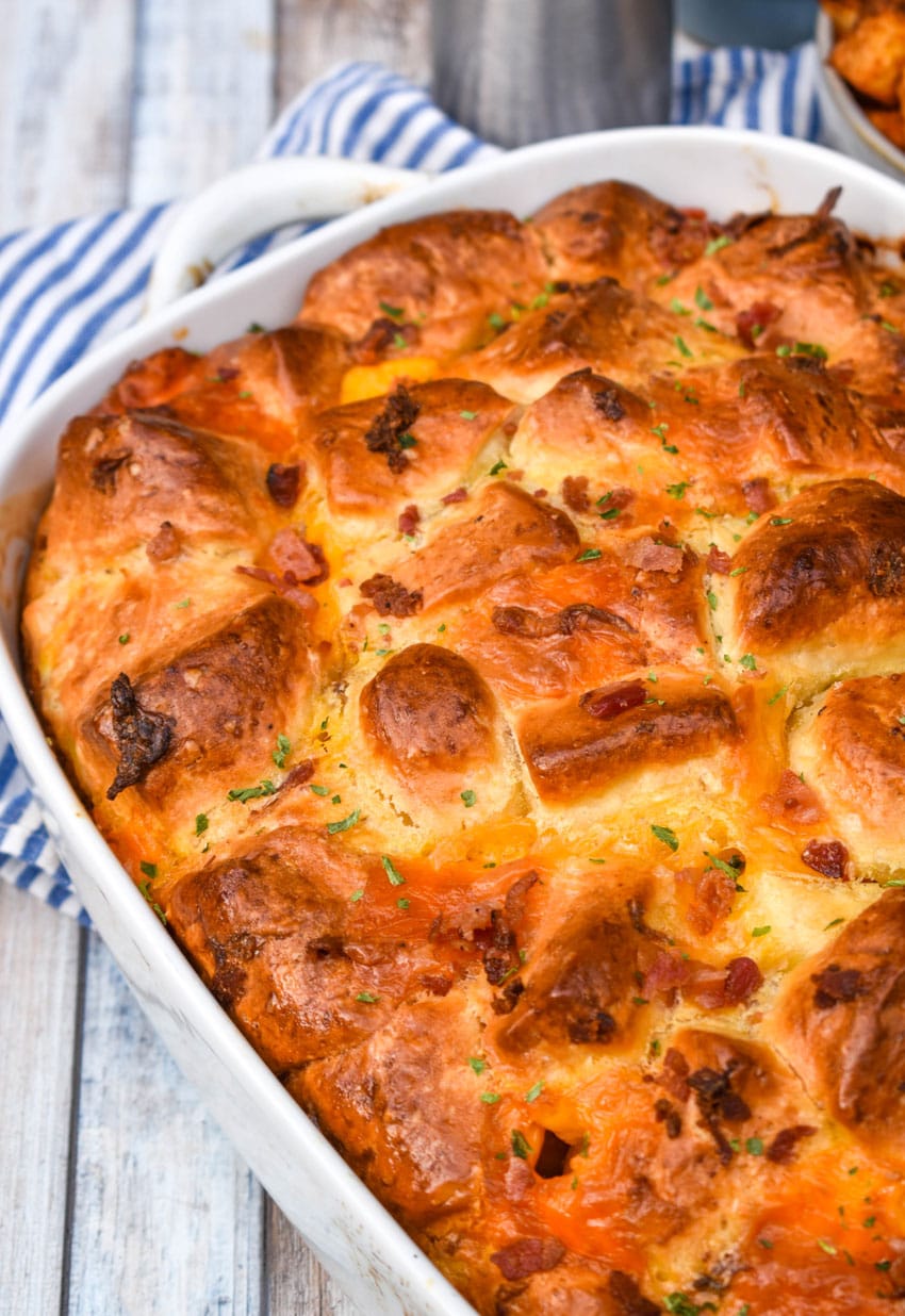 cheesy bacon egg breakfast biscuit bake in a white casserole dish
