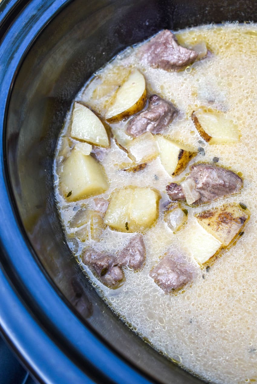 creamy steak and potato soup in the black crock of a slow cooker