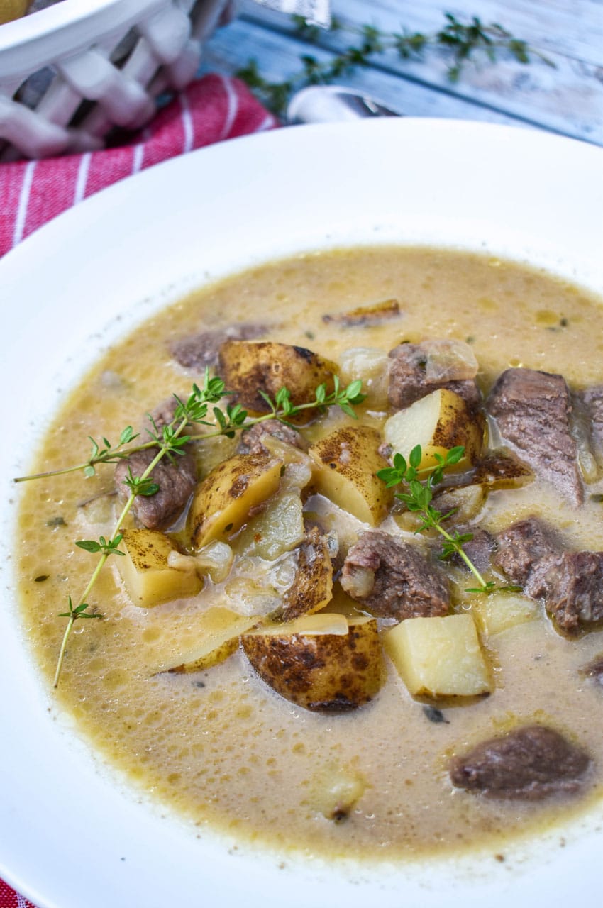 creamy steak and potato soup in a white soup bowl