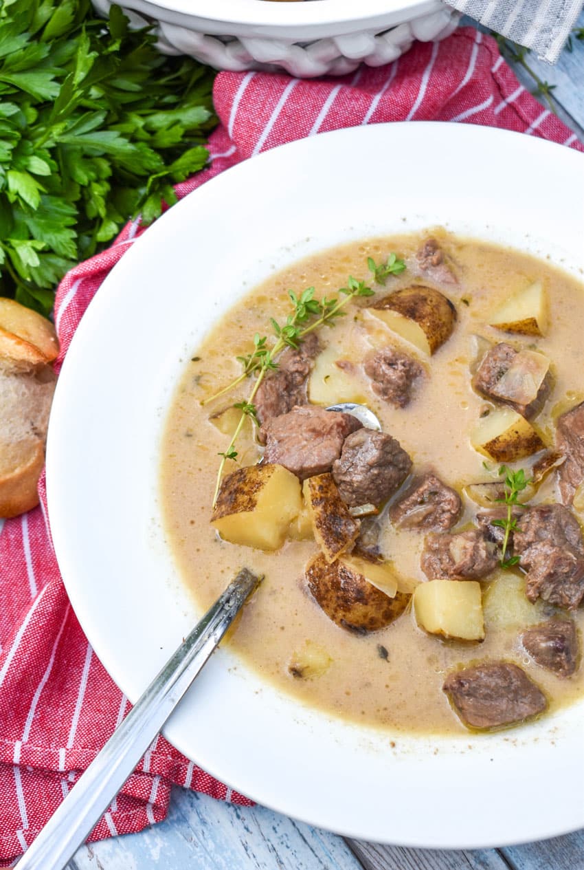 creamy steak and potato soup in a white soup bowl