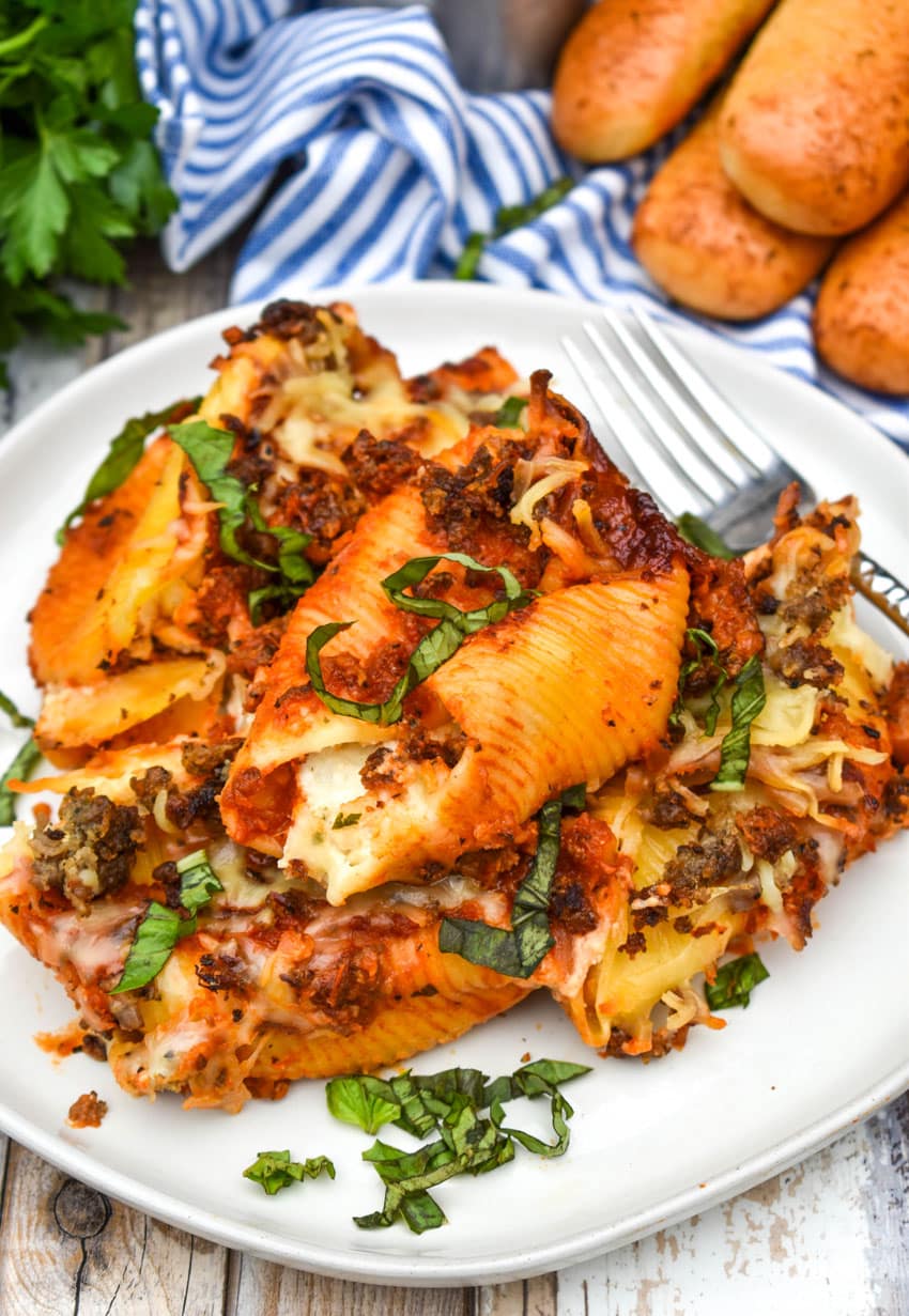 slow cooker stuffed shells on a white plate garnished with fresh basil