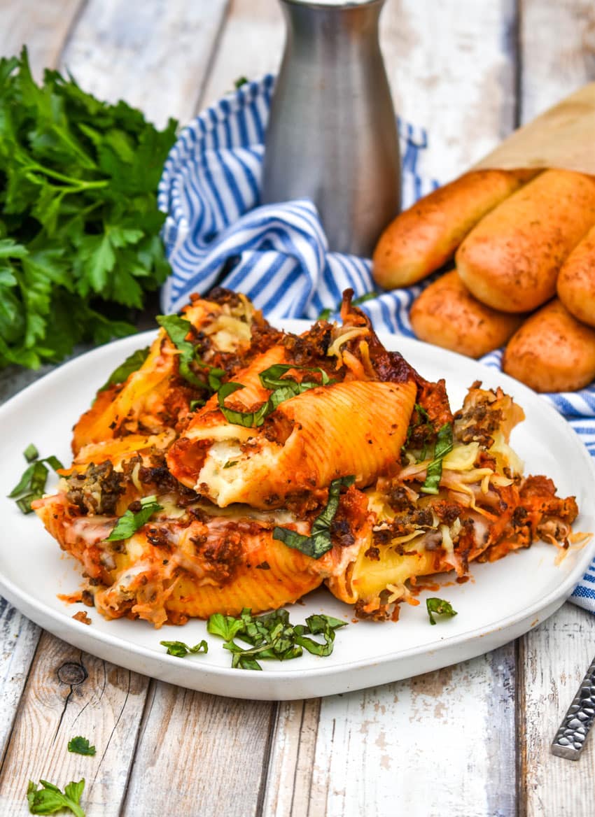 slow cooker stuffed shells on a white plate garnished with fresh basil