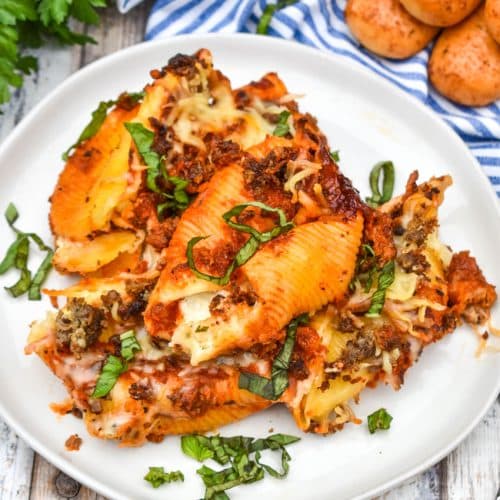 slow cooker stuffed shells on a white plate garnished with fresh basil