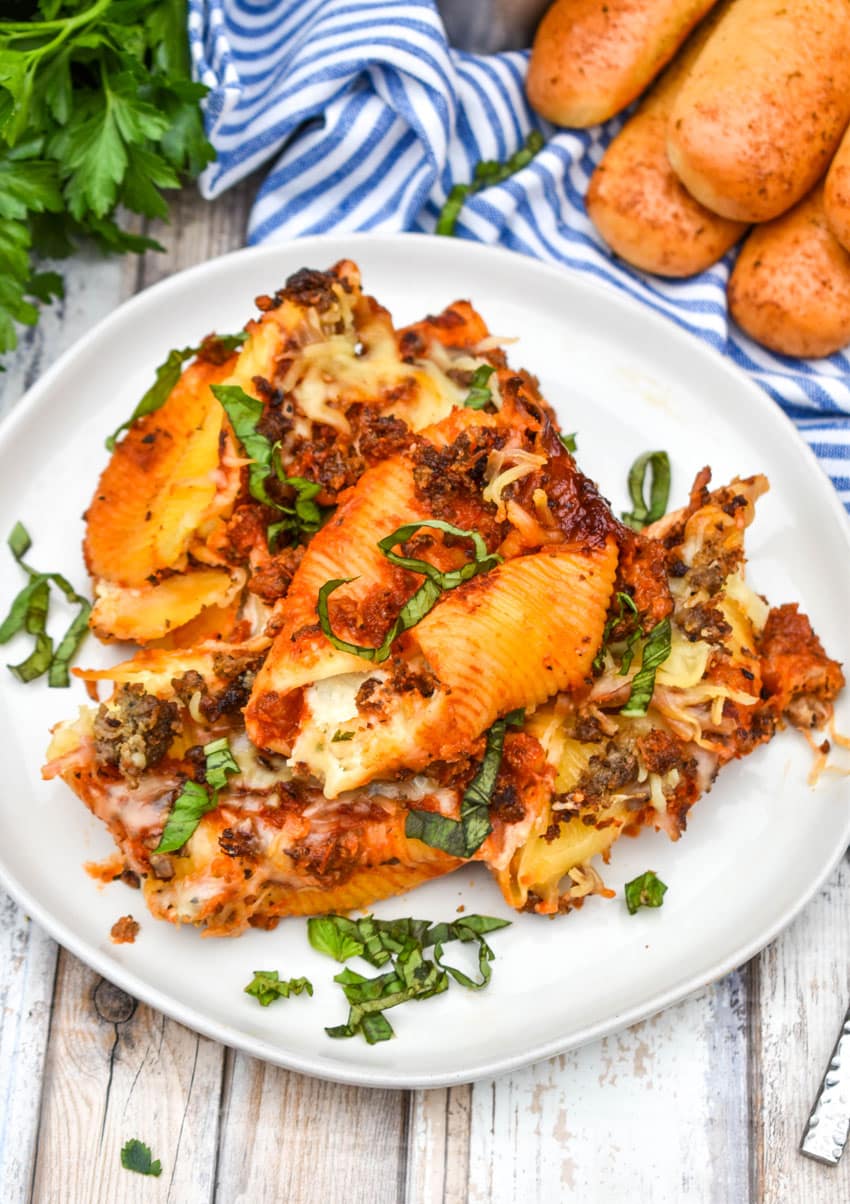 slow cooker stuffed shells on a white plate garnished with fresh basil