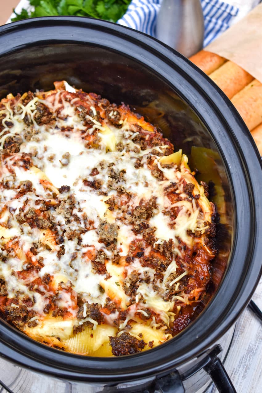 slow cooker stuffed shells in the bowl of a black crockpot