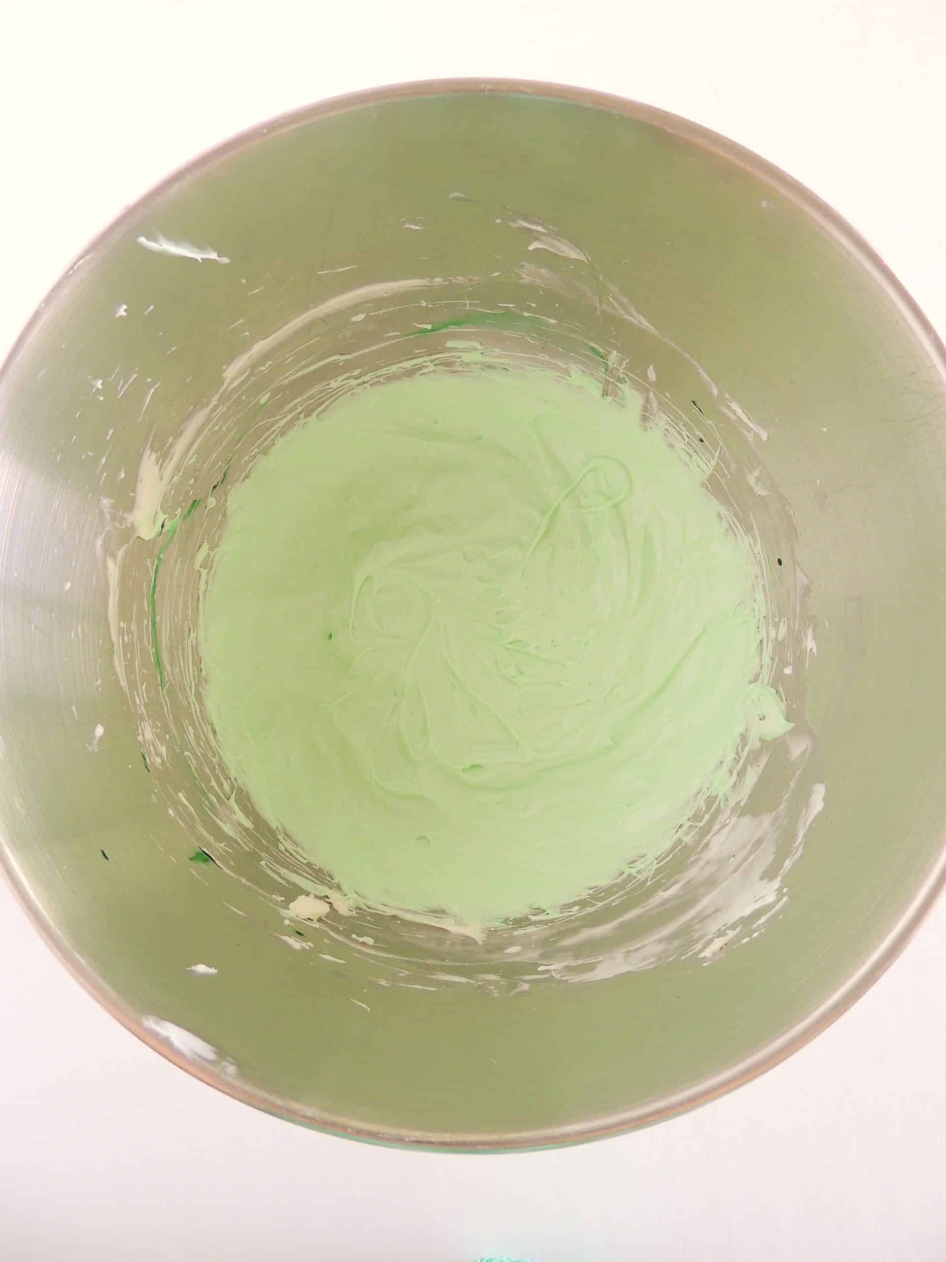 green colored marshmallow fruit dip in a metal mixing bowl