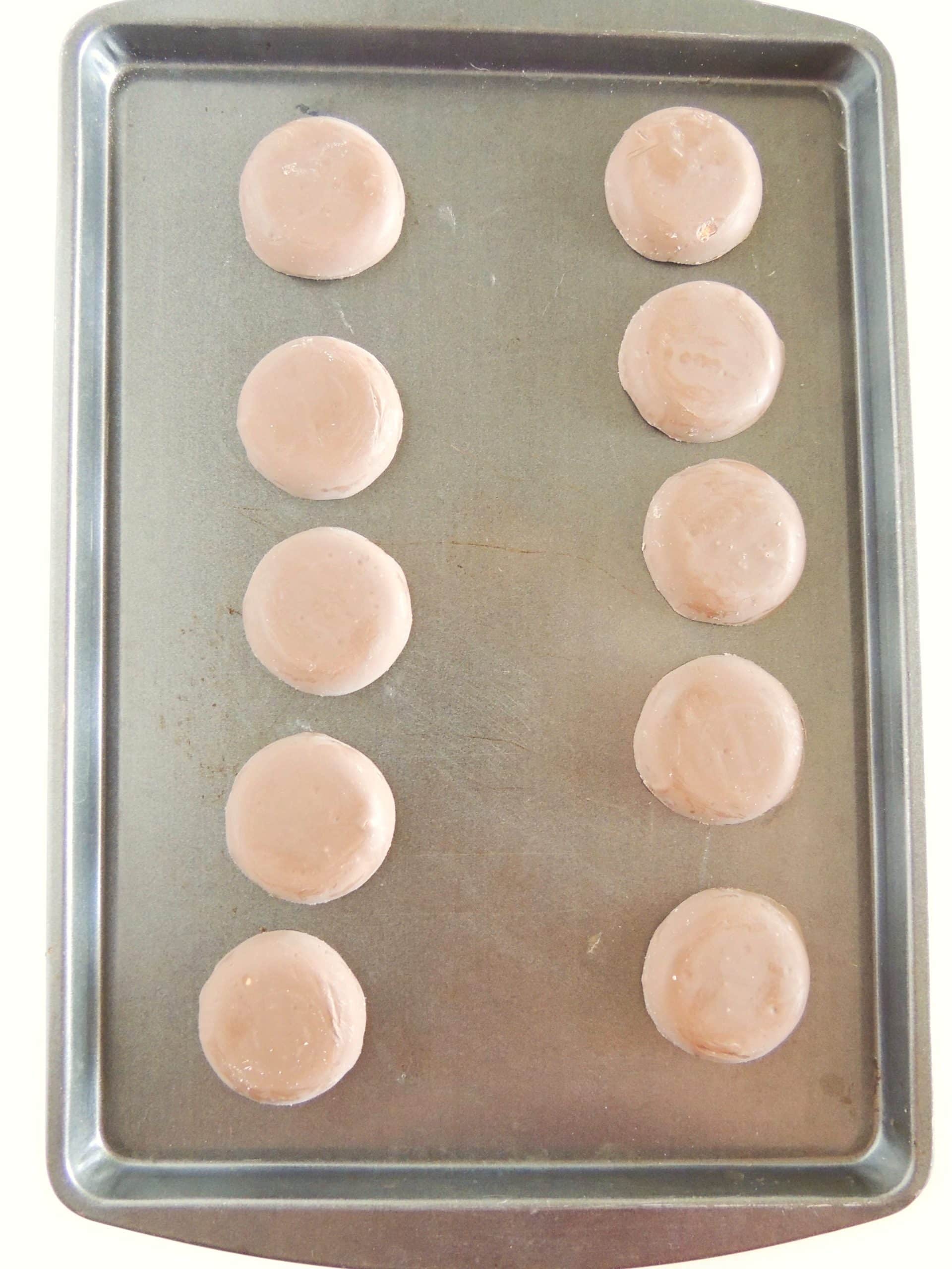 fudge covered cookies arranged in two rows on a metal baking sheet