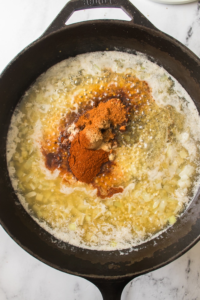 seasonings in melted butter in a black skillet