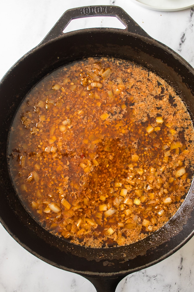 seasoned butter and onions in a black skillet