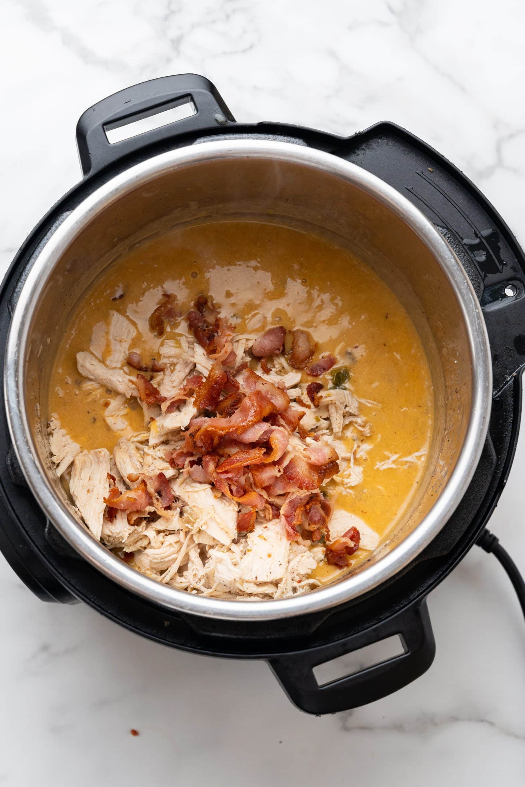 chicken and bacon in a cheese sauce in the bowl of an instant pot