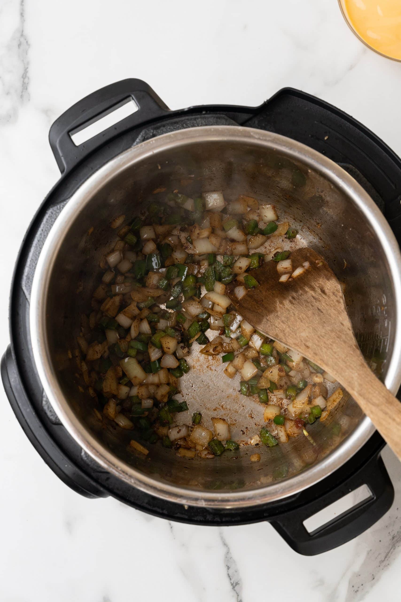 sauteed onions and peppers in the bowl of an instant pot