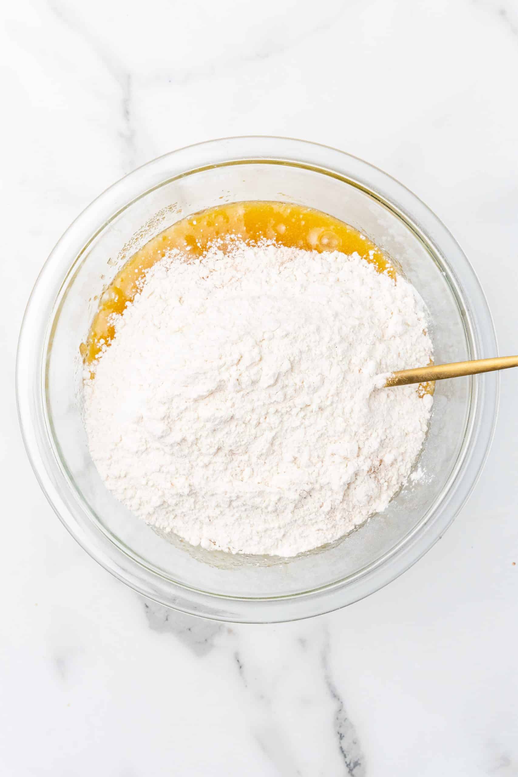 apple upside down cake batter in a glass mixing bowl