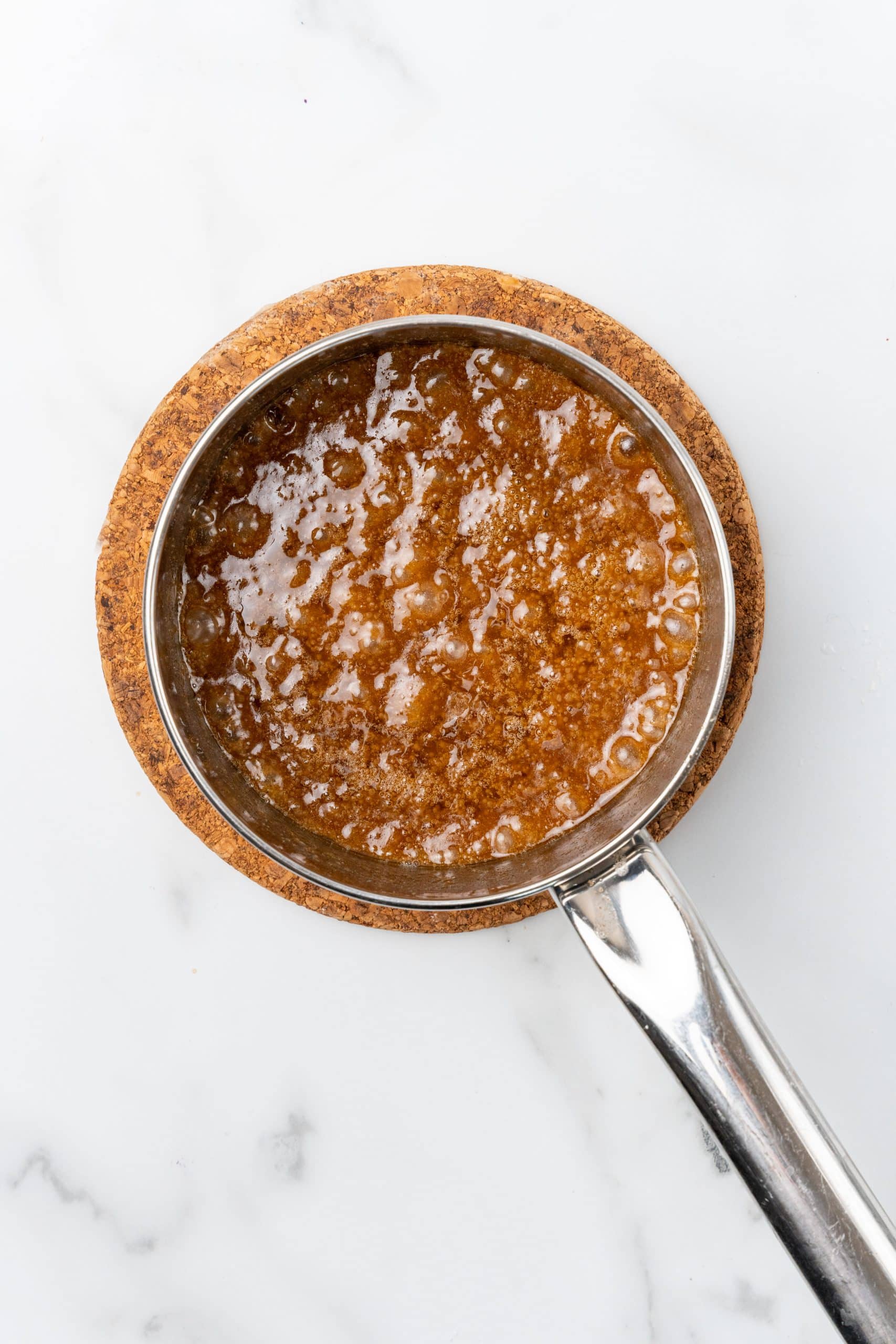homemade caramel sauce in a small silver pot
