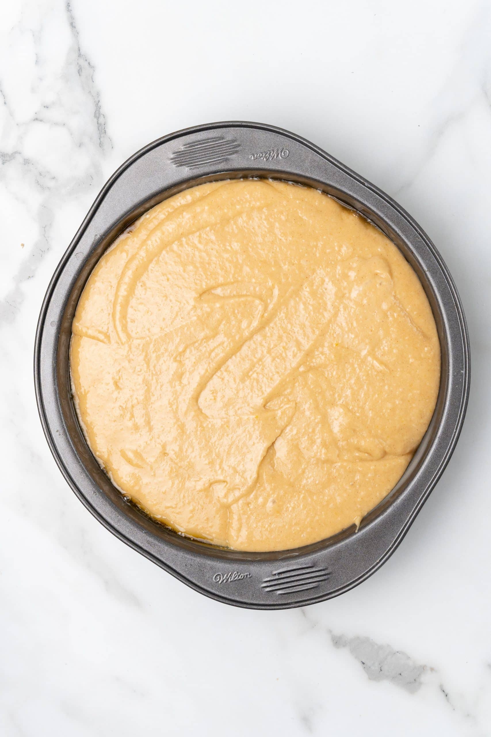 upside down apple cake batter in a round cake pan