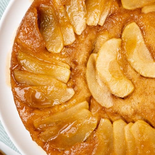apple upside down cake on a white serving plate