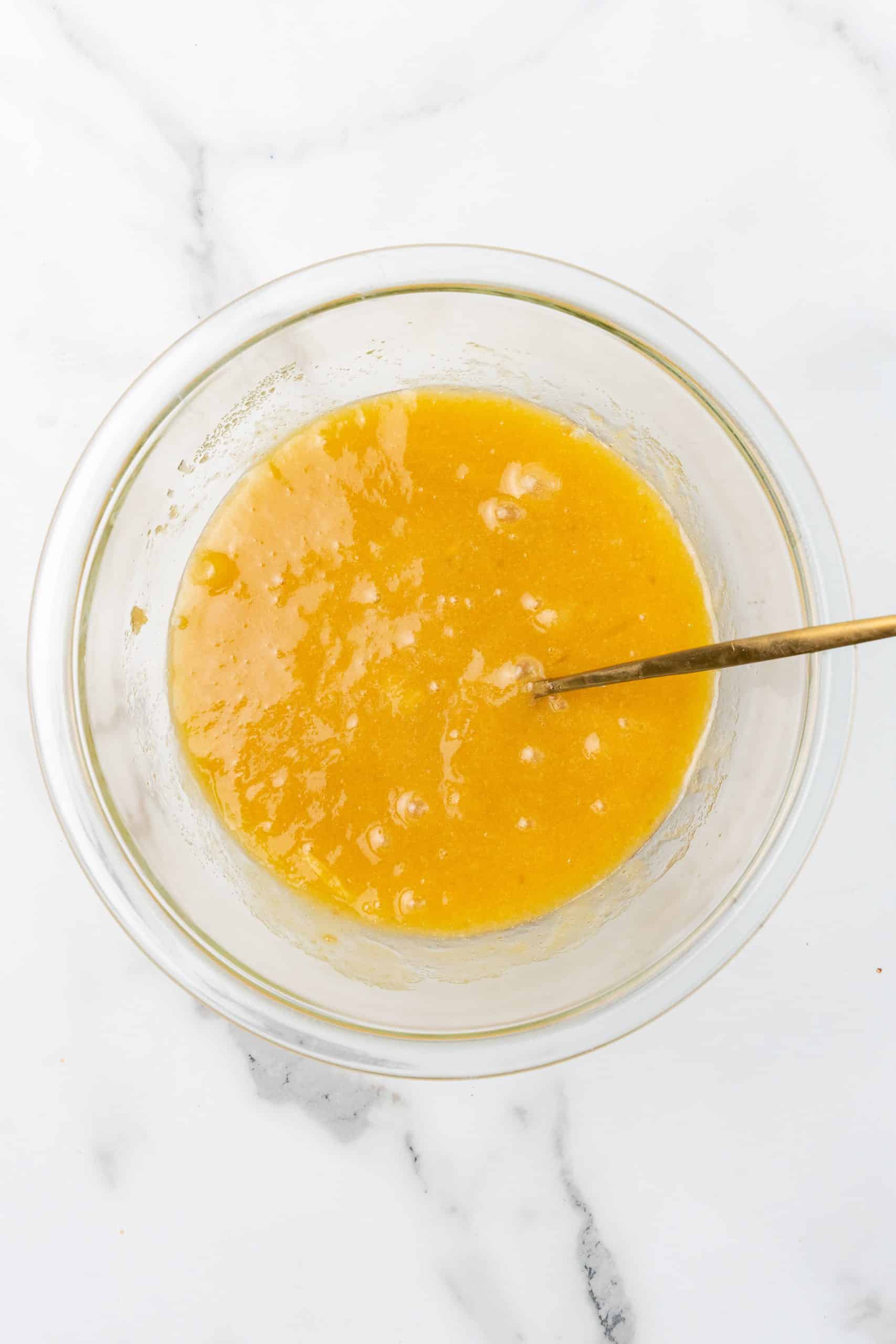 apple upside down cake batter in a glass mixing bowl