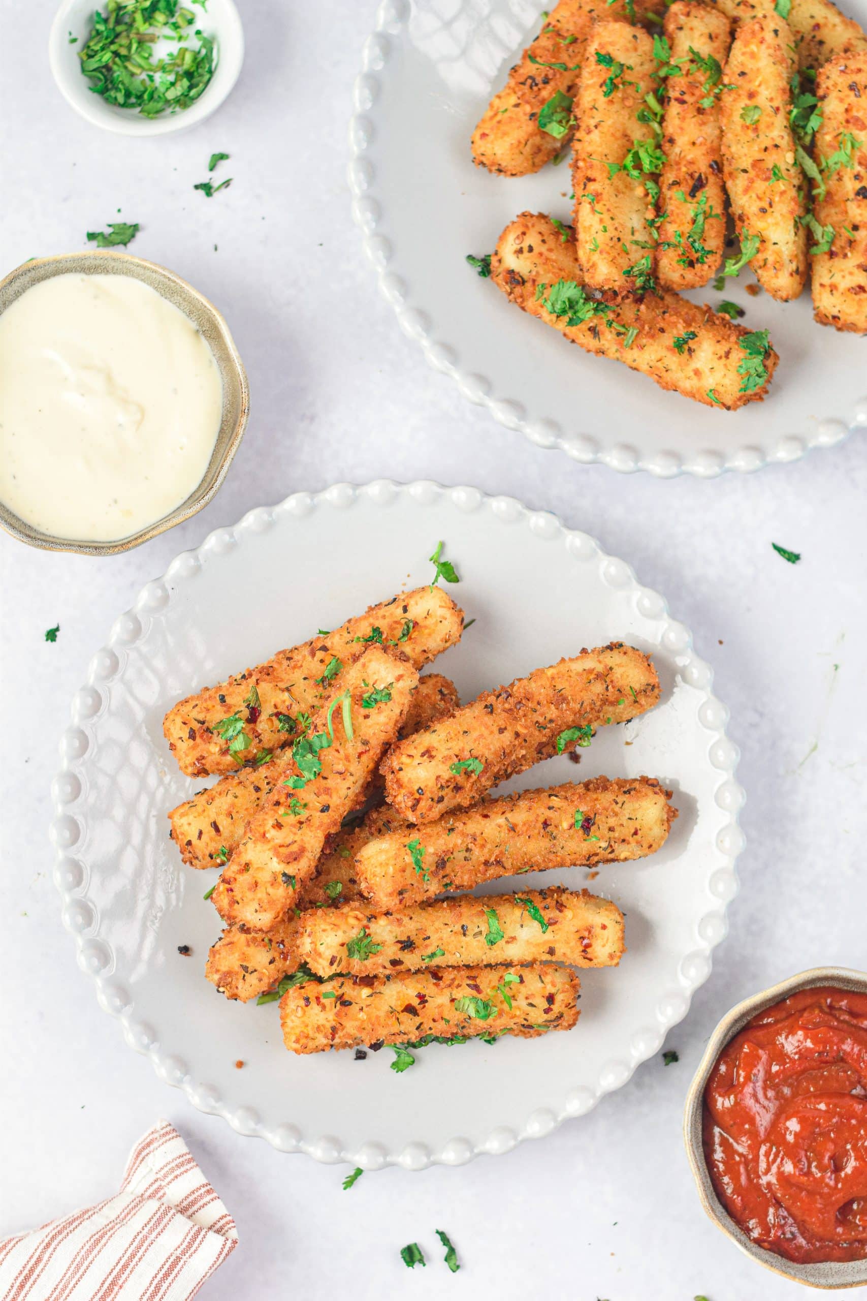 air fryer mozzarella sticks on a white plate with fresh herbs
