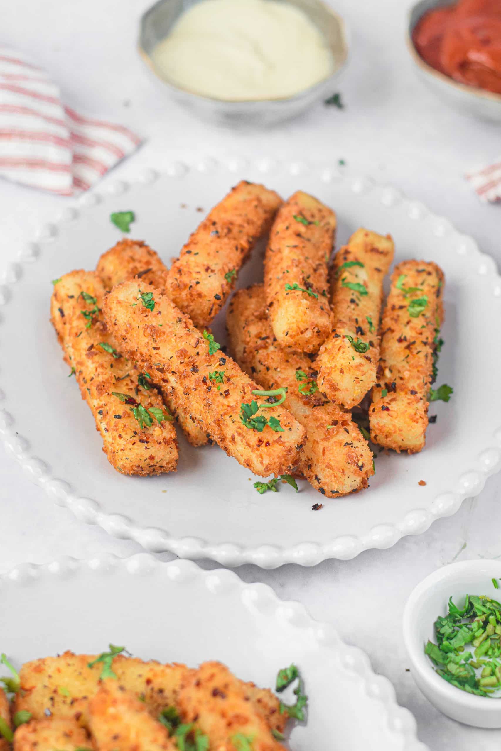 air fryer mozzarella sticks on a white plate with fresh herbs