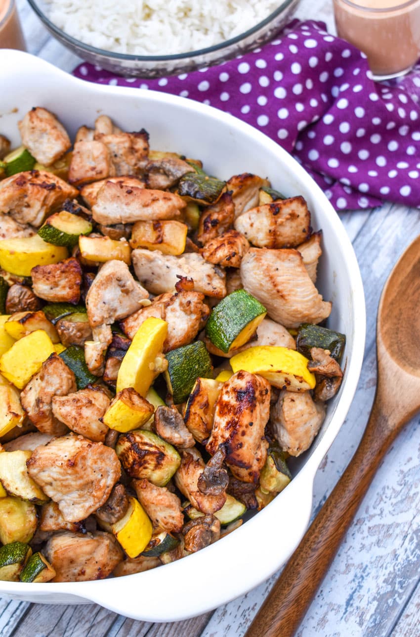easy homemade hibachi chicken and vegetables in a white serving bowl with a wooden spoon on the side