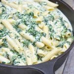 creamed spinach mac and cheese in a cast iron skillet