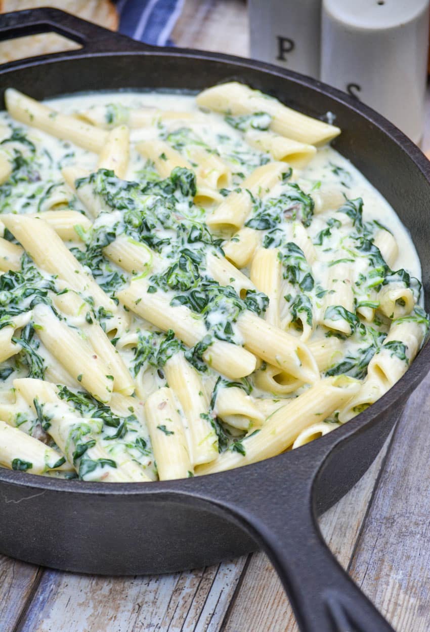 creamed spinach mac and cheese in a cast iron skillet