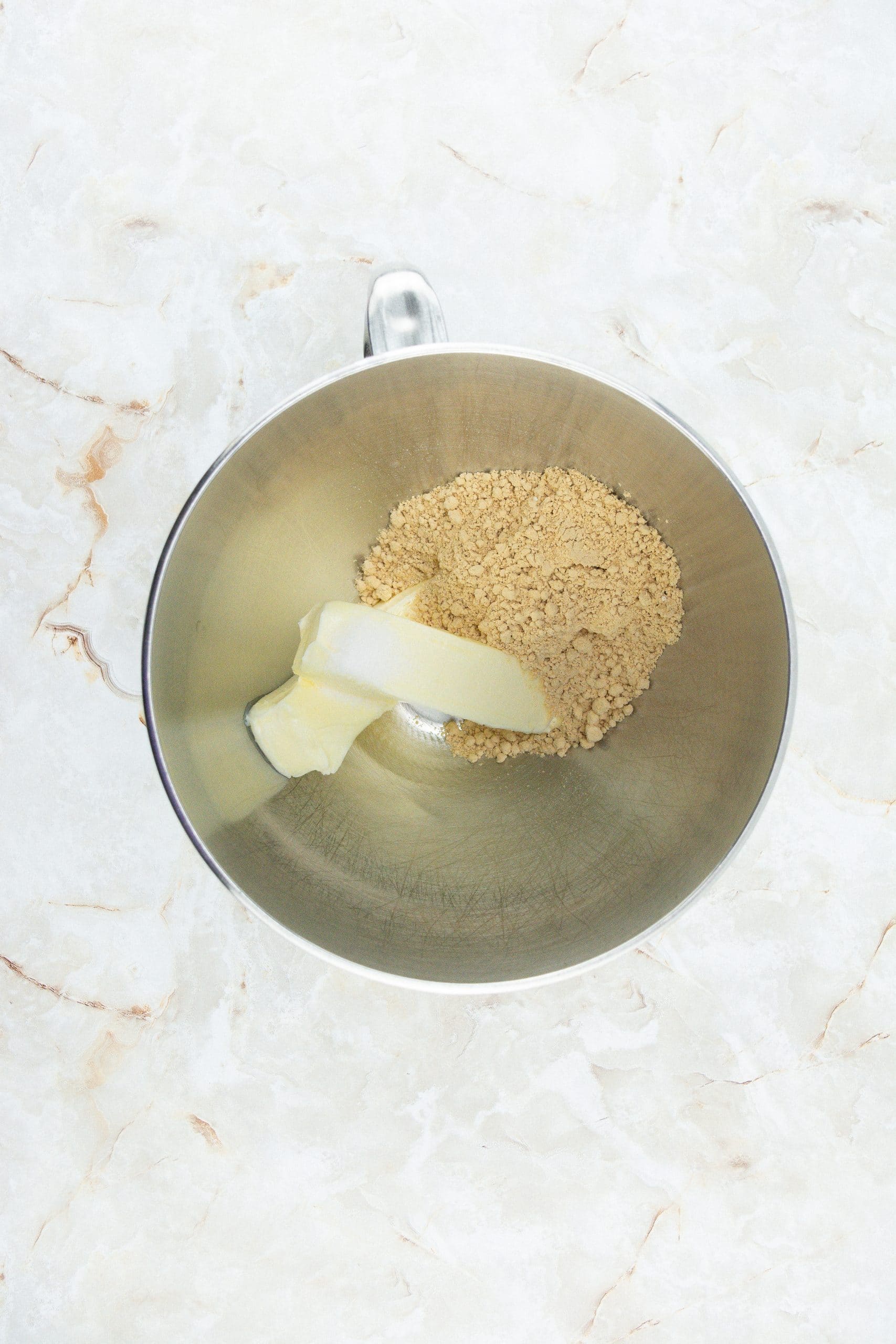 sticks of butter and sugar in a metal mixing bowl