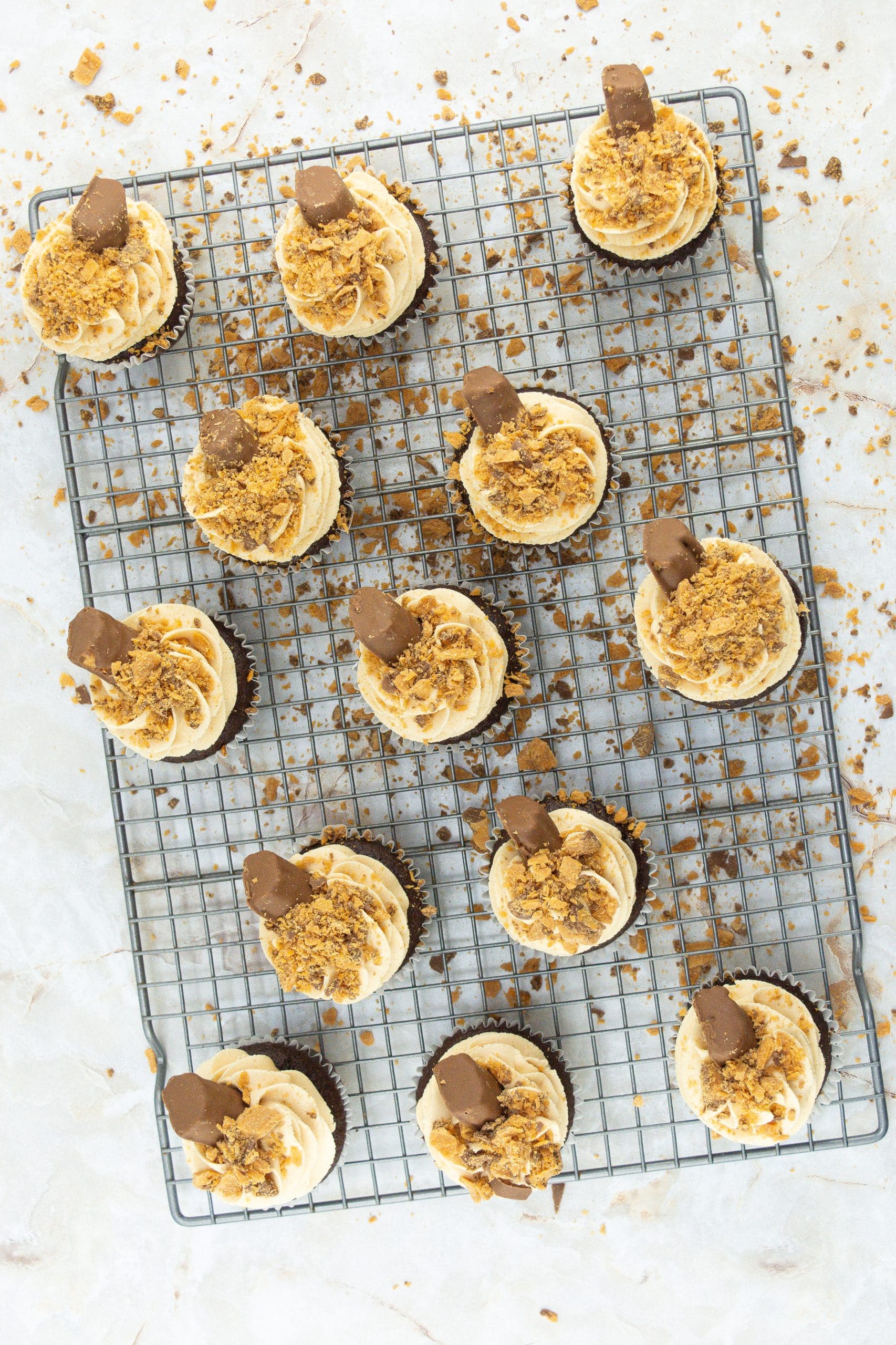 decorated butterfinger cupcakes on a wire rack