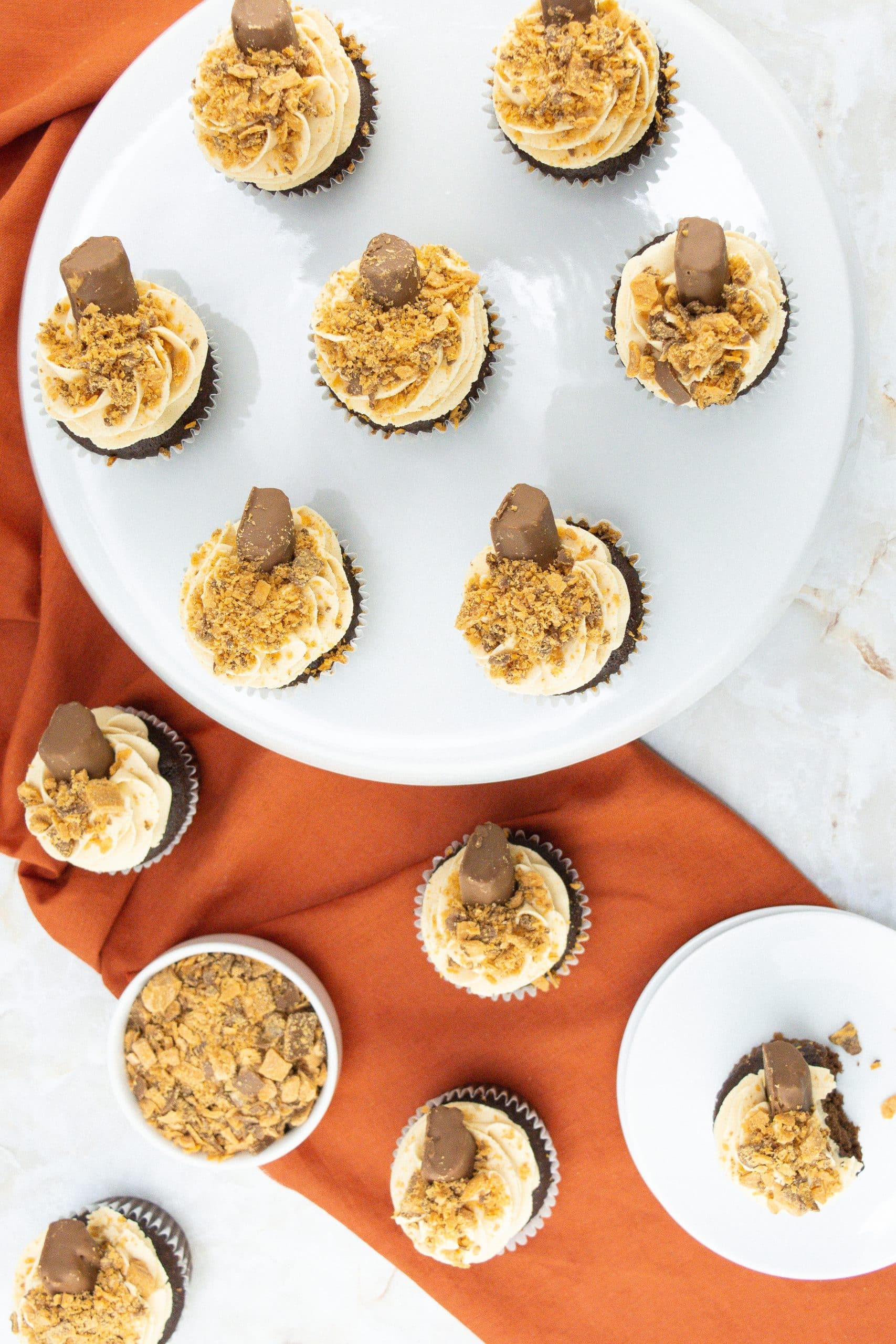 butterfinger cupcakes on a white cake stand