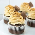 butterfinger cupcakes on a white cake stand