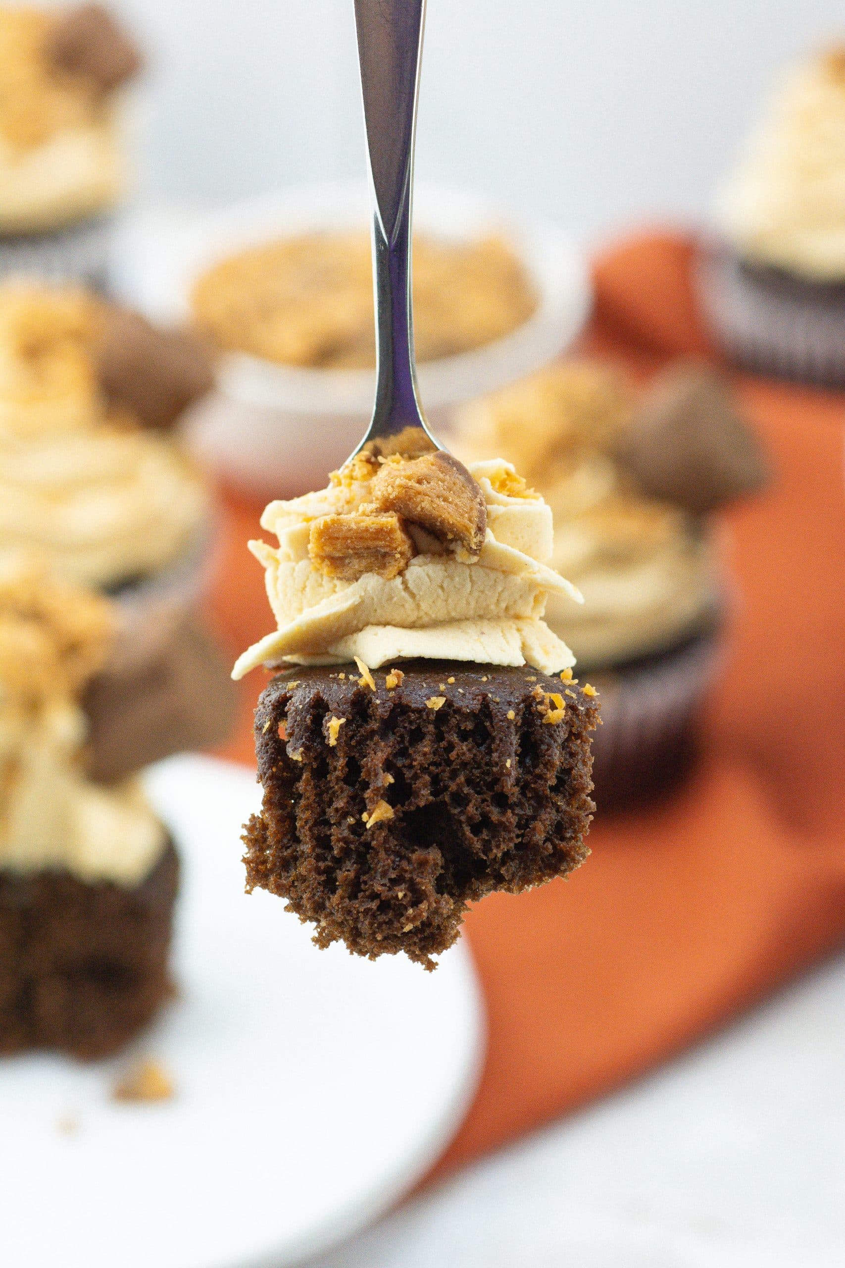 a black fork holding up a scoop of a butterfinger cupcake
