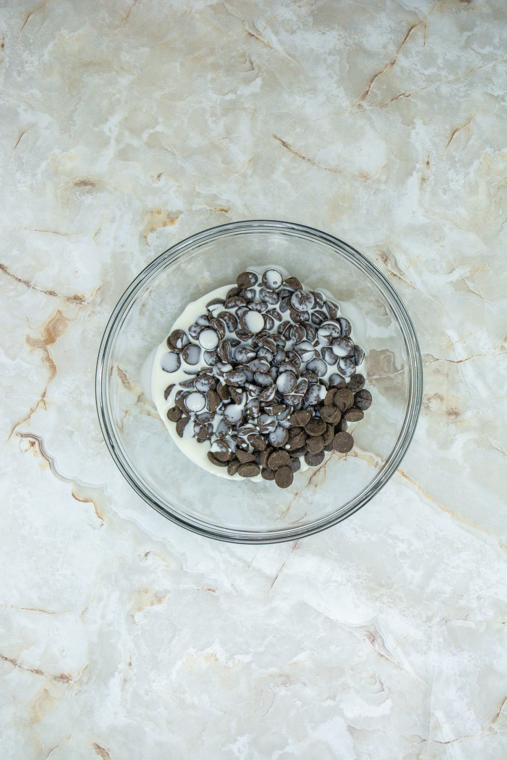 peppermint flavored chocolate ganache ingredients in a small glass mixing bowl