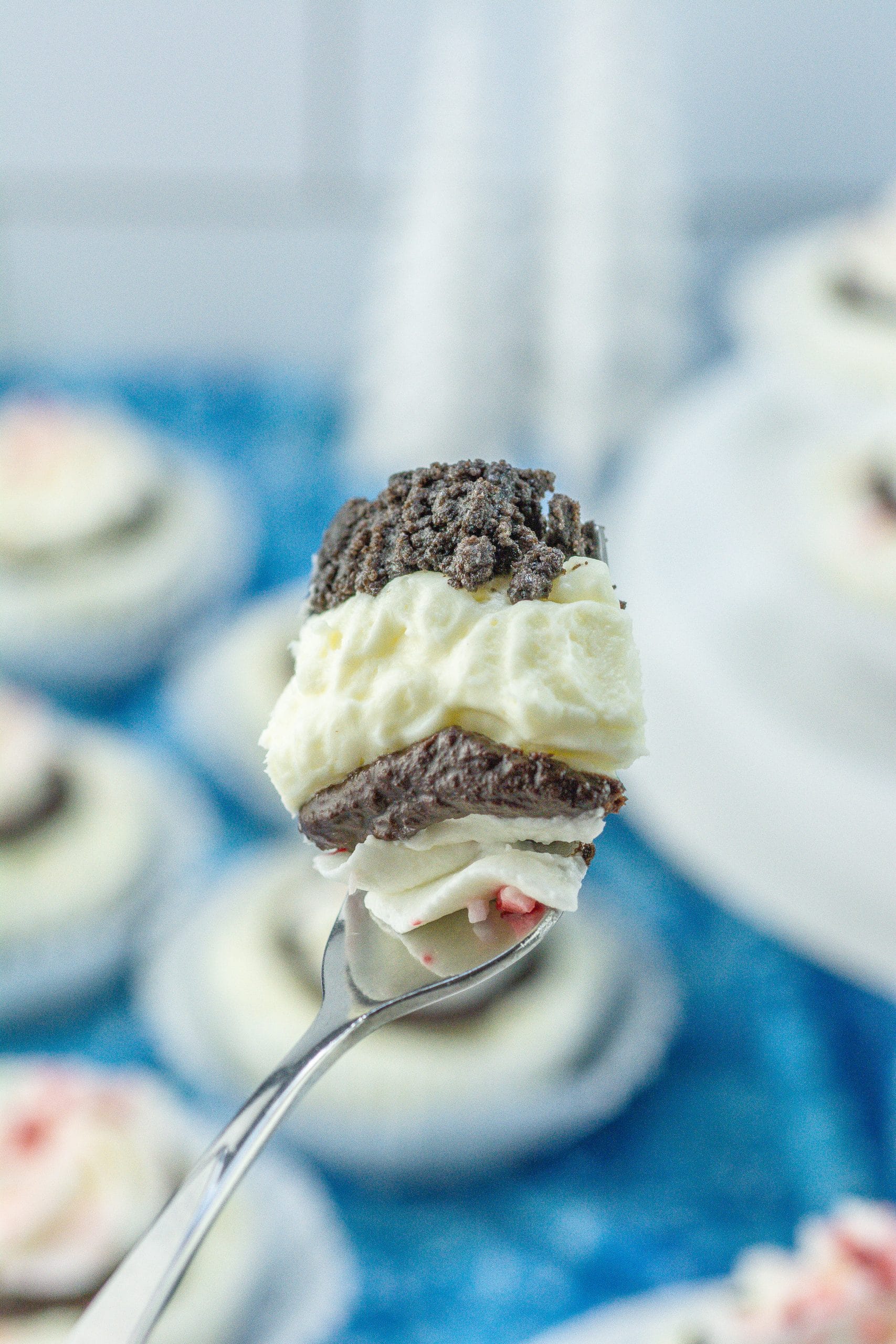 a silver fork holding up a scoop of peppermint cheesecake bites
