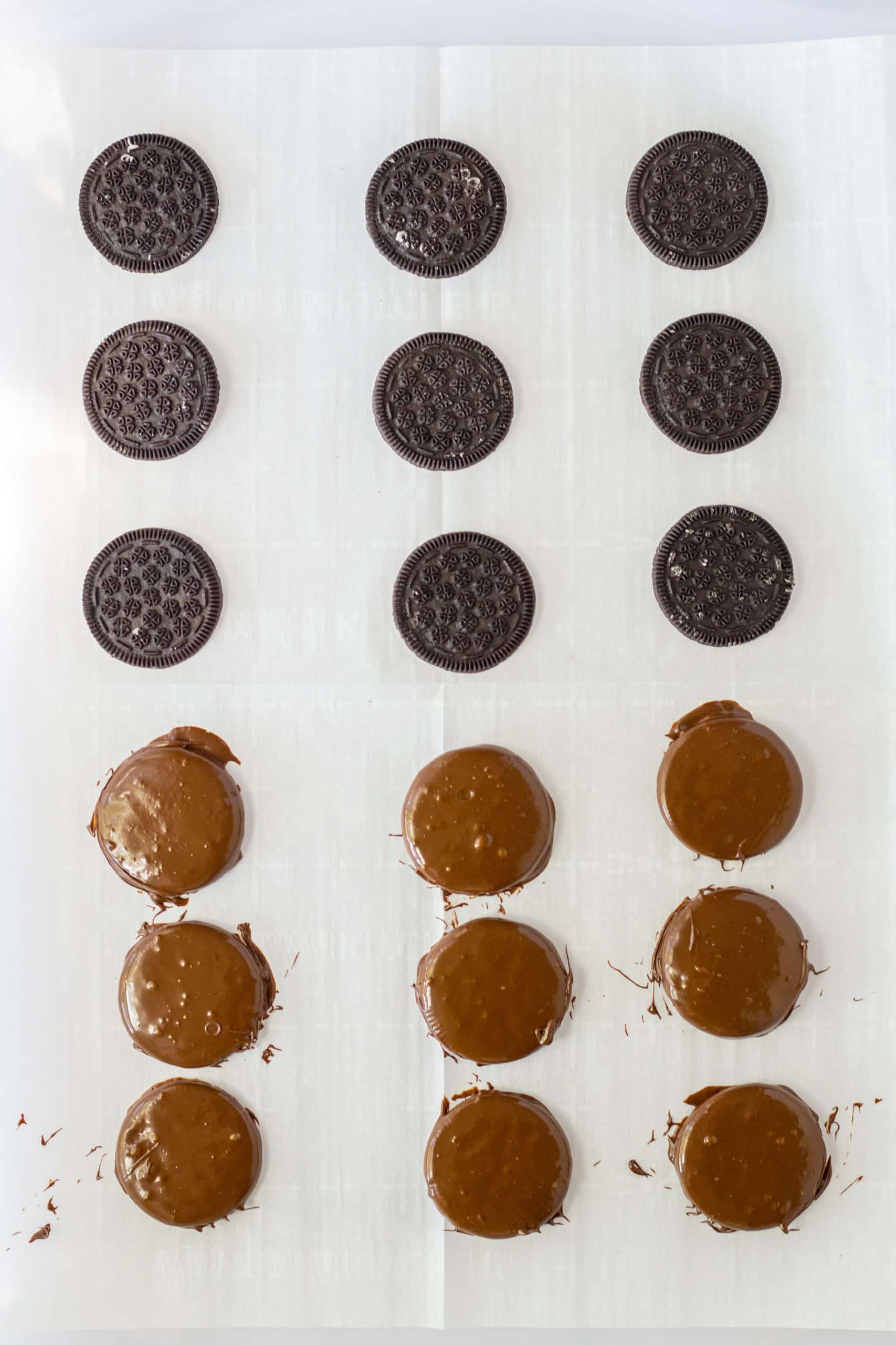 chocolate covered oreo cookies arranged in rows on parchment paper