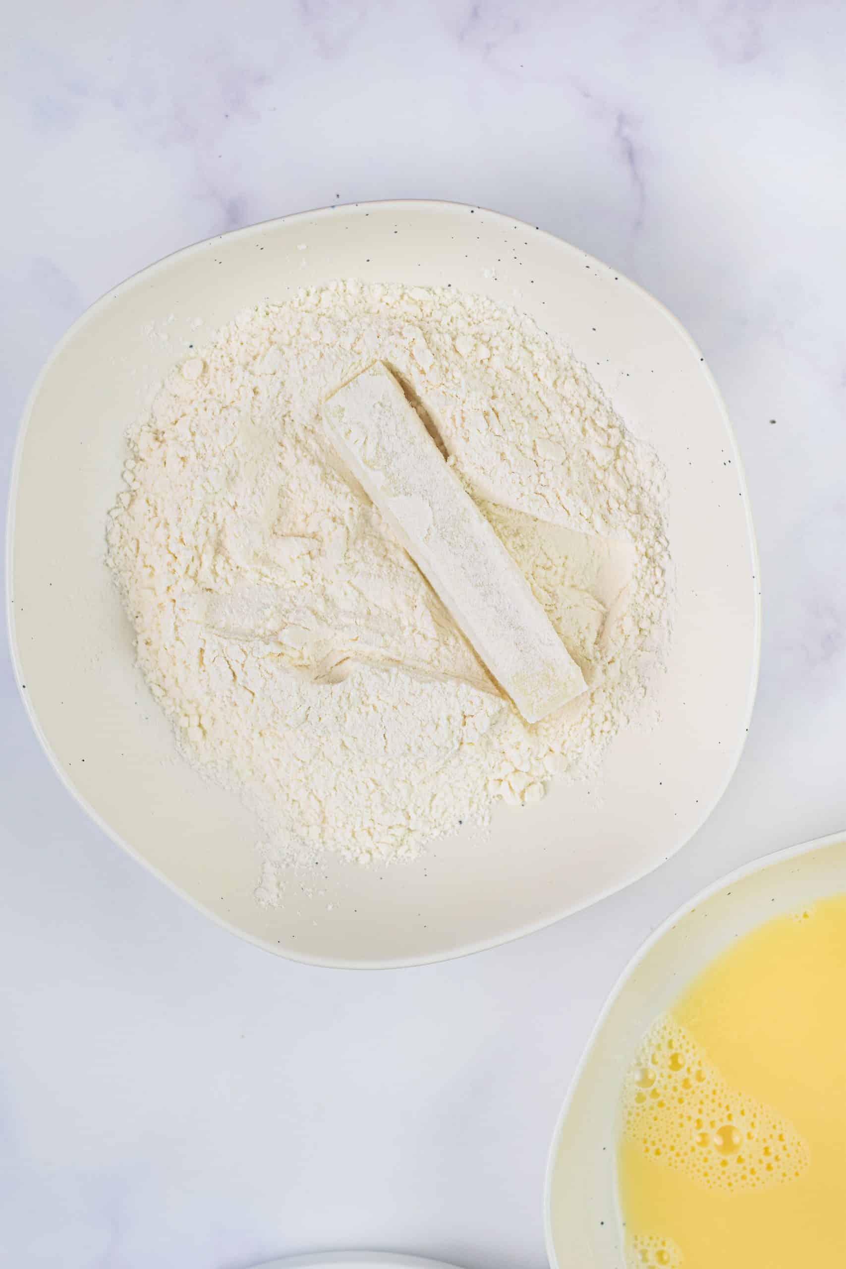 a piece of mozzarella cheese coated in flour on a white plate