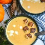 pumpkin soup in black bowls topped with cinnamon sugar croutons